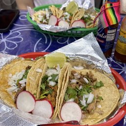 a plate of tacos and a bottle of beer a plate of tacos and a bottle of beer