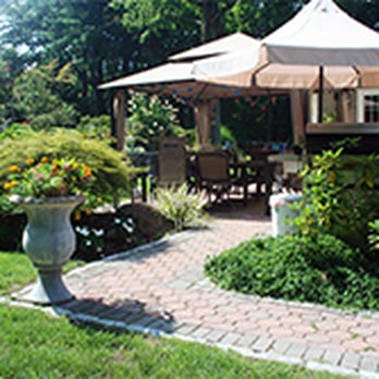 Gomes Lawn & Masonry - a patio with a table and chairs - Landscaping Near Me - Buchanan, New York Gomes Lawn & Masonry - a patio with a table and chairs - Landscaping Near Me - Buchanan, New York