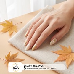 Chan’s Nails & Spa - Gilded harvest flora! Glossy almond nails pair champagne metallic chrome and milky vanilla polish with dainty golden leaf vines. Book!