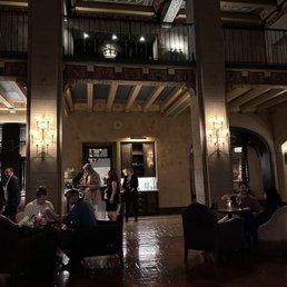 people sitting at tables in a hotel lobby