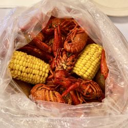 Li's Seafood Boil - Two pounds of head-on crawfish with juicy corn on the cob and redskin potatoes, served in a steamed bag boil with tasty butter/cajun broth!