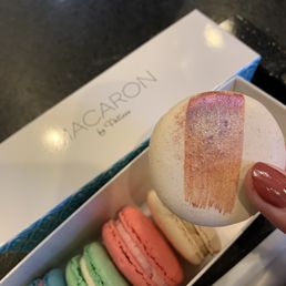 Half dozen macarons with chai chocolate being held up Half dozen macarons with chai chocolate being held up