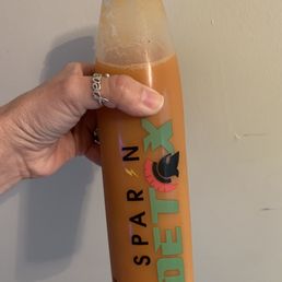 a hand holding a bottle of drink a hand holding a bottle of drink