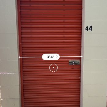 Public Storage - Small door for "5x15" unit - A red metal storage unit door with a lock, set in a beige wall, with a measurement overlay indicating 3 feet 4 inches. - Self Storage Near Me - Cranston, Rhode Island
