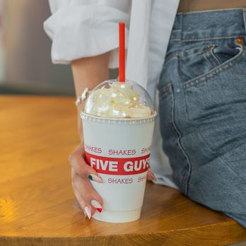 Five Guys - A close-up photograph of a woman holding a Five Guys milkshake. - Burgers Near Me - Lebanon, New Hampshire