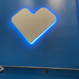 a neon heart on a blue wall