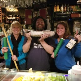 a group of people holding up a fish a group of people holding up a fish