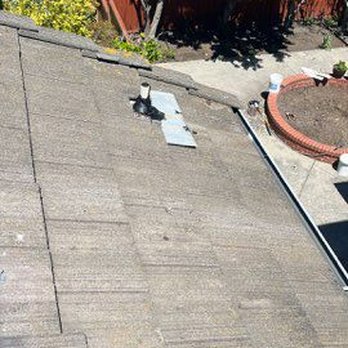 Precise Roofing - An aerial view of a rooftop shows a vent, shingles, and the shadow of the photographer taking the picture. - Roofing Near Me - Walnut Creek, California