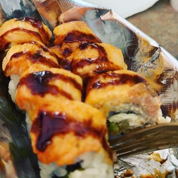 Sushibucks - Lion King Roll - A sushi roll with eel sauce drizzled on top, served in a foil container, with visible rice and filling ingredients. - Japanese Near Me - Albuquerque, New Mexico
