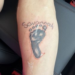 Mr. Tattoo - My wife's hand writing with my daughter's footprint. Several shades of dark and a touch of white.