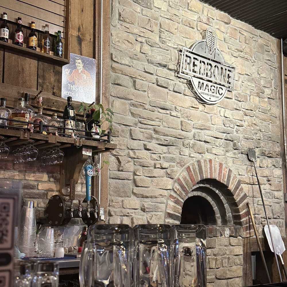 Redbone Magic Brewing - Wood fired pizza oven and the Redbone Magic sign overhead. - Breweries Near Me - Texarkana, Texas