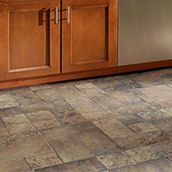 iDeal Floors - a kitchen with wood cabinets and tile flooring - Flooring Near Me - Plano, Texas
