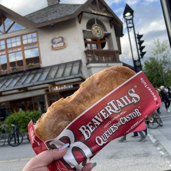 BeaverTails - a person holding a bag of chips in front of a building - Desserts Near Me - Banff, Alberta BeaverTails - a person holding a bag of chips in front of a building - Desserts Near Me - Banff, Alberta