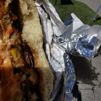 Dragon's Lair Burger - a hand holding a sandwich - Burgers Near Me - Calgary, Alberta