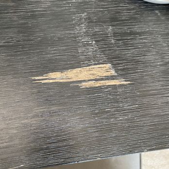 Chamomile Moving - Vanity desk that wasn't properly shrink-wrapped. Tape residue left behind and wood gash came off with removing the tape. - Movers Near Me