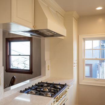 Caliber Construction and Design - After - Window view with pass through. Custom hood vent cover, custom cabinetry. - General Contractors Near Me
