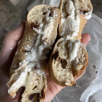 Big Apple Bagels - a hand holding a bagel with a bite taken out of it - Bagels Near Me - Naperville, Illinois