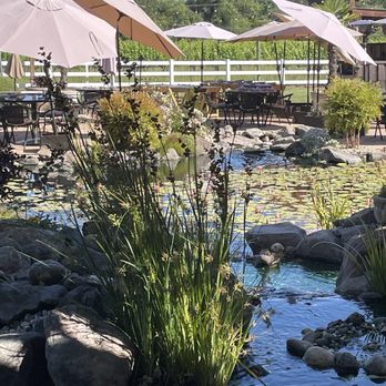 Salt & Stone - View of koi pond and tables with umbrellas - Wine Bars Near Me - Kenwood, California