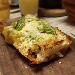 Tavola - CHEESY CIABATTA - a garlicky spin on the classic ciabatta bread, served with pesto, melted cheese, and parmesan.