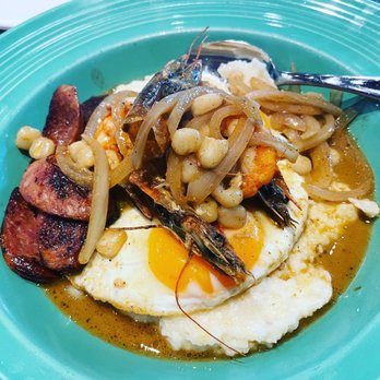 Scratch Kitchen - CREOLE SHRIMP N' SAUSAGE GRITS Sautéed garlic shrimp, andouille sausage, white hominy, onions, gravy, two island eggs, grits. - Breakfast & Brunch Near Me - Honolulu, Hawaii Scratch Kitchen - CREOLE SHRIMP N' SAUSAGE GRITS Sautéed garlic shrimp, andouille sausage, white hominy, onions, gravy, two island eggs, grits. - Breakfast & Brunch Near Me - Honolulu, Hawaii