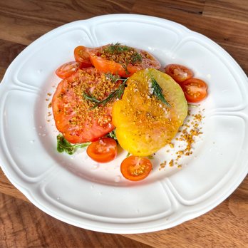 Restaurant Claudine - Heirloom tomato salad with arugula, green goddess vinaigrette, seed crumble, and pistachio - French Near Me - San Antonio, Texas Restaurant Claudine - Heirloom tomato salad with arugula, green goddess vinaigrette, seed crumble, and pistachio - French Near Me - San Antonio, Texas