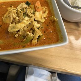 Pumpkin Curry - A bowl of pumpkin curry soup with shredded chicken and vegetables, served with a side of white rice in a separate bowl at Da Ra Cafe & Brew.