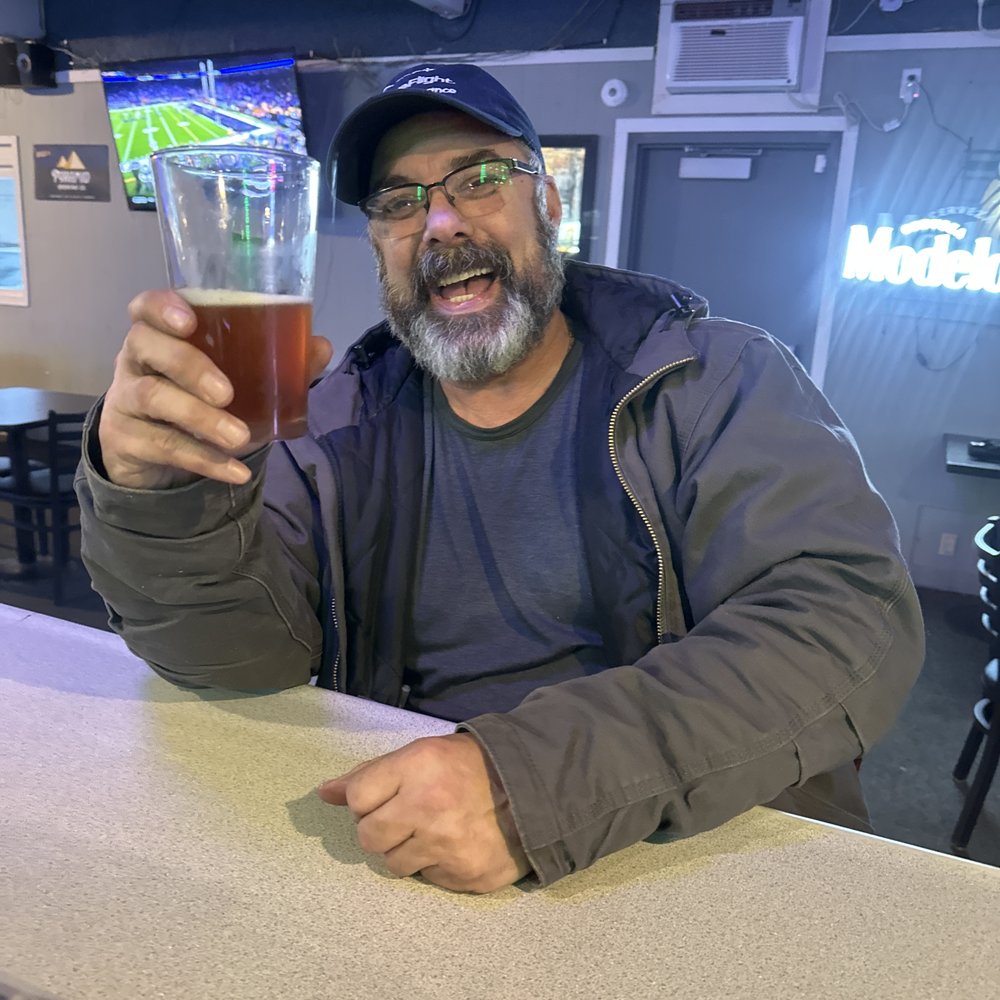 a man holding a glass of beer a man holding a glass of beer