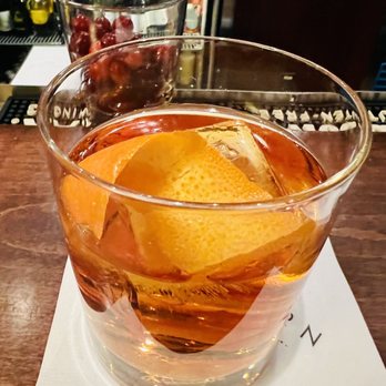TEN - a drink in a glass with an orange peel - New American Near Me - Billings, Montana TEN - a drink in a glass with an orange peel - New American Near Me - Billings, Montana