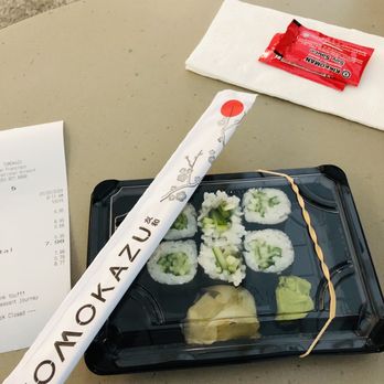 Tomokazu - a roll of sushi on a tray - Japanese Near Me Tomokazu - a roll of sushi on a tray - Japanese Near Me