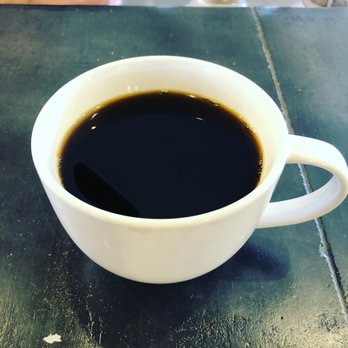 The House - a cup of coffee on a table - Coffee & Tea Near Me - Ogden, Kansas