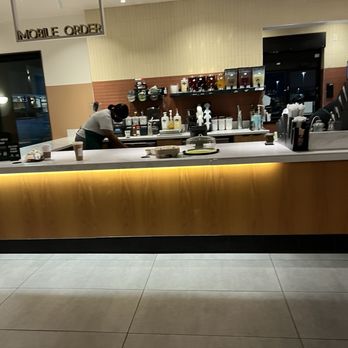 Starbucks - a coffee shop with a counter and a person sitting at the counter - Coffee & Tea Near Me - Laurel, Maryland