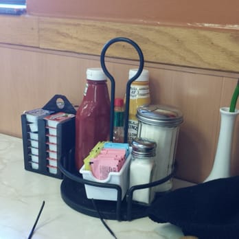 The Round Table Cafe - Available condiments.  Note the bottle of Tabasco and the flower in the vase! - American Near Me - Belleville, Illinois