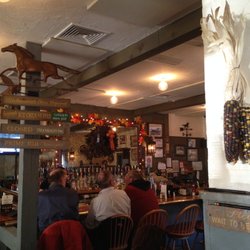 Quaint pub with a few spots at the bar, and several dining tables tucked to the left of this area.