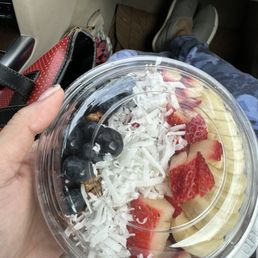 a person holding a plastic bowl of fruit a person holding a plastic bowl of fruit