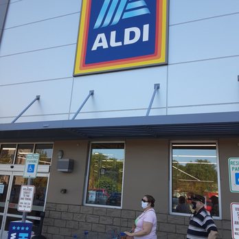 ALDI - a woman and a man with a shopping cart in front of a aldi store - Grocery Near Me - Homestead, Pennsylvania
