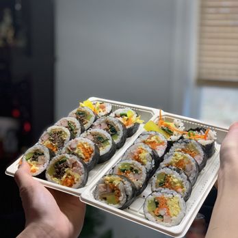 Rollin Plus - a person holding a tray of sushi - Korean Near Me - Scarborough, Ontario