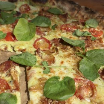 E9 Brewing - Aug 2025, one of the Special pizzas. SO GOOD. Watercress and tomato to cut the richness of bacon and provolone. - Breweries Near Me - Tacoma, Washington