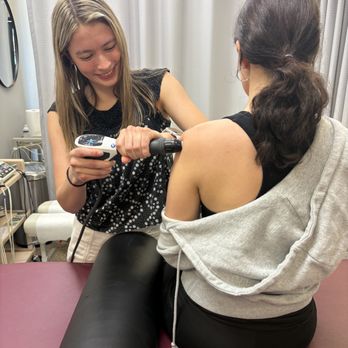 Zozzaro Chiropractic & Rehab - A woman getting shockwave therapy on her shoulder at Zozzaro Chiropractic and Rehab in Normal IL - Chiropractors Near Me - Normal, Illinois Zozzaro Chiropractic & Rehab - A woman getting shockwave therapy on her shoulder at Zozzaro Chiropractic and Rehab in Normal IL - Chiropractors Near Me - Normal, Illinois