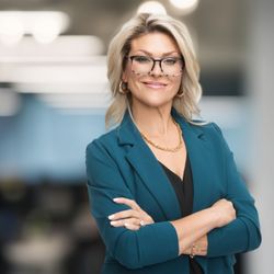 Janel Lee Photography - Confident woman smiling in teal blazer, modern Cincinnati office backdrop, Janel Lee Photography headshot.