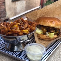 Burger à la Une - Burger "Double smash spicy" avec des frites et une sauce Deluxe.