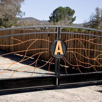 Impact Welding & Fabrication - This custom gate features a black steel frame with rust patina solid rods and a custom freeform design. - Metal Fabricators Near Me Impact Welding & Fabrication - This custom gate features a black steel frame with rust patina solid rods and a custom freeform design. - Metal Fabricators Near Me