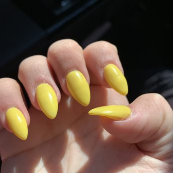 LA Nails - Close-up of a hand with five fingers, showcasing yellow, almond-shaped, glossy manicured nails. - Nail Salons Near Me - Springfield, Oregon