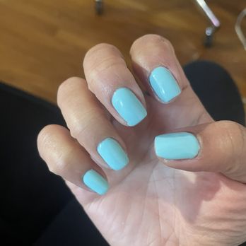Ruby Nails - Gel manicure - Close-up of a hand with light blue gel manicure, displaying nails and some skin imperfections, in an indoor setting. - Nail Salons Near Me - Weymouth, Massachusetts