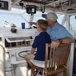 Fish The Bay Charters - CAPT Phil showing my 7 year-old how to drive the boat