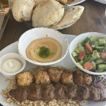 Ammatoli - chicken kebab and kafta skewers served on a bed of vermicelli rice, greek salad and spicy hummus and fresh pita bread - Mediterranean Near Me - Long Beach, California Ammatoli - chicken kebab and kafta skewers served on a bed of vermicelli rice, greek salad and spicy hummus and fresh pita bread - Mediterranean Near Me - Long Beach, California