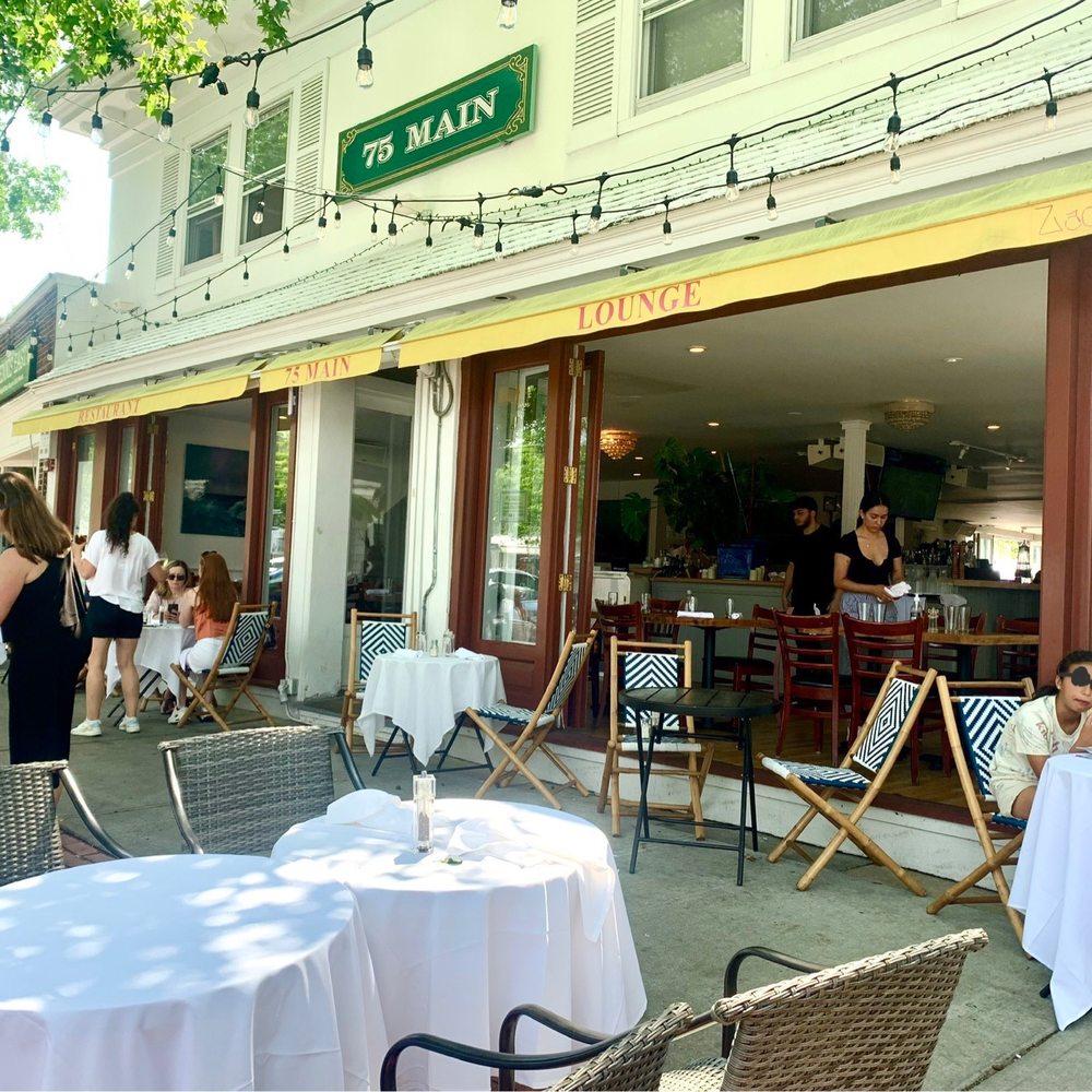 75 Main - Very popular outside seating area. Nicely shaded at lunchtime. Doors are wide open for some inside seating to feel part of the outside - New American Near Me - Southampton, New York 75 Main - Very popular outside seating area. Nicely shaded at lunchtime. Doors are wide open for some inside seating to feel part of the outside - New American Near Me - Southampton, New York