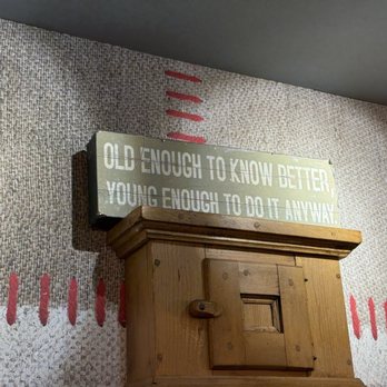 Raclette Factory - Humorous saying at back end of dining room next to open kitchen: "Old enough to know better, Young enough to do it anyway" - Swiss Food Near Me - Zürich, ZH Raclette Factory - Humorous saying at back end of dining room next to open kitchen: "Old enough to know better, Young enough to do it anyway" - Swiss Food Near Me - Zürich, ZH
