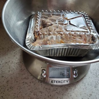 South Moon BBQ - Our pound if pulled pork... - A foil container with food is on a digital kitchen scale, showing a weight of 12.5 ounces, on a speckled countertop. - Barbeque Near Me - Hinckley, Illinois