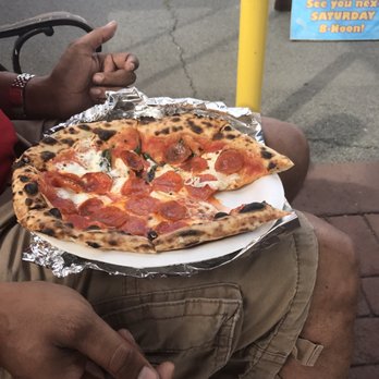 Fire Dance Pizza - a man holding a plate of pizza - Pizza Near Me - Kailua, Hawaii