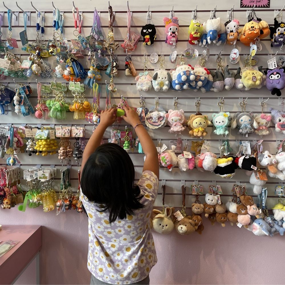 Kid looking through a selection of cute keychains.
